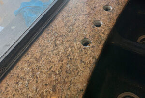This image shows a repaired granite countertop. There is no longer a crack behind the sink faucet.